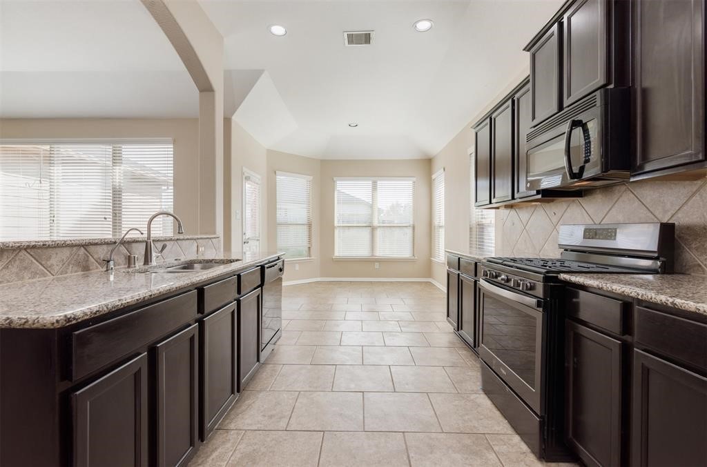 1903 Cadbury Castle Lane Fresno, TX 77545 - Photo 8 of 14 a kitchen with stainless steel appliances granite countertop a sink stove and cabinets