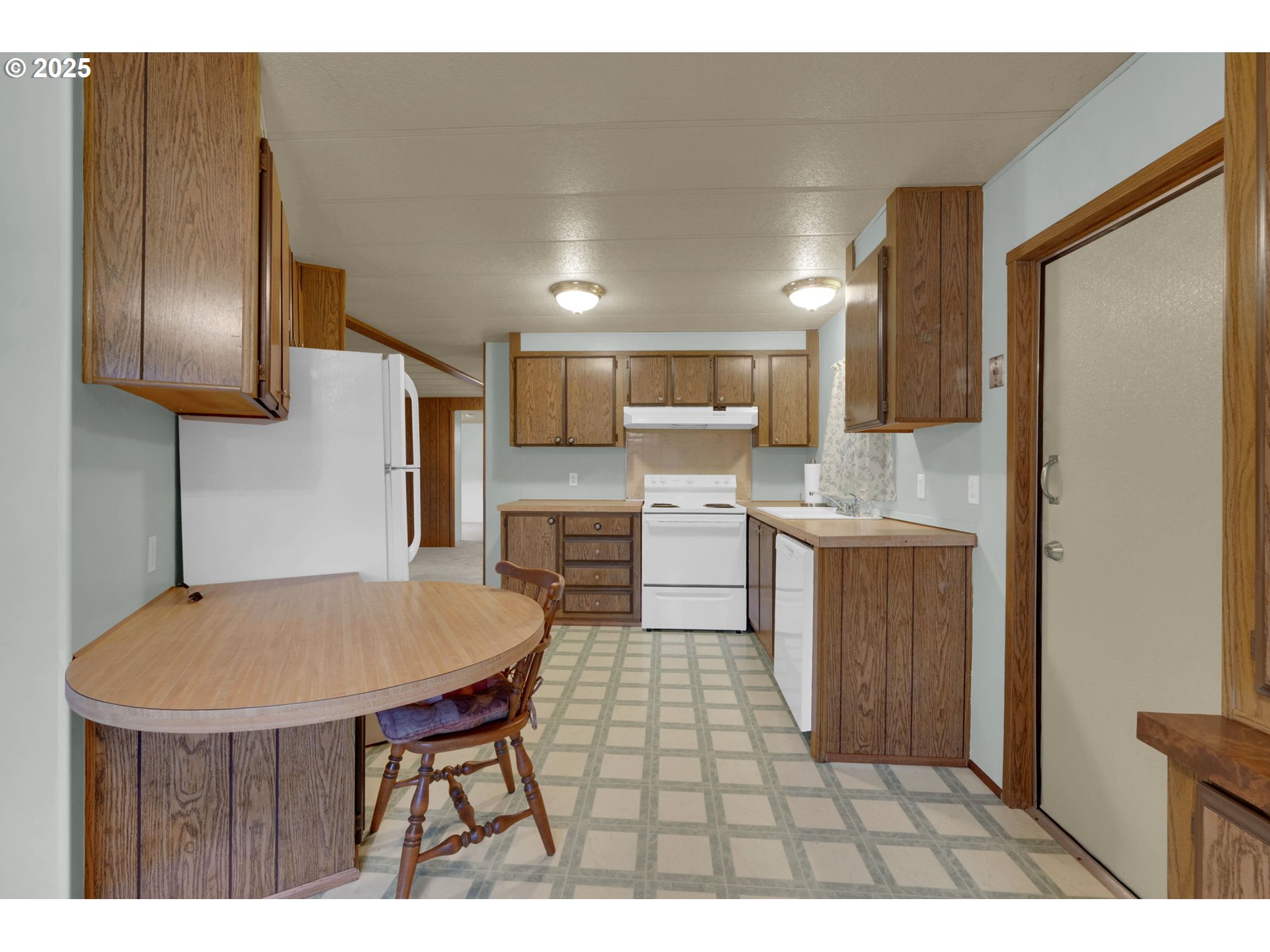 1475 Green Acres Road, Unit 13 Eugene, OR 97408 - Photo 11 of 39 a kitchen with kitchen island a counter top space a sink stainless steel appliances and cabinets