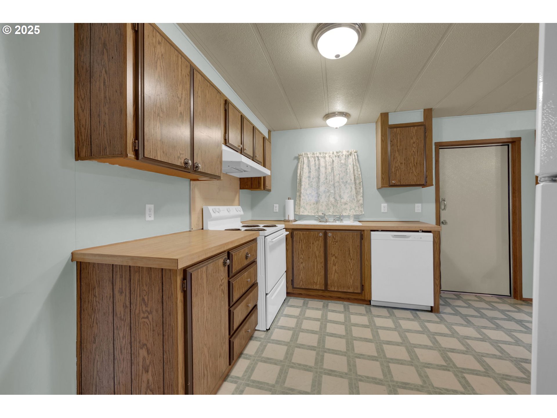 1475 Green Acres Road, Unit 13 Eugene, OR 97408 - Photo 12 of 39 a kitchen with a stove a sink and a refrigerator