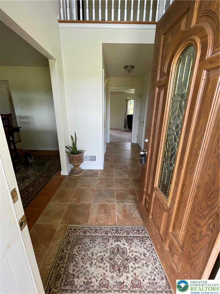 707 Gilbert Road Gilbert, PA 18331 - Photo 7 of 56 A grand wood entry door welcomes you into a luminous tiled foyer, offering a peek at the flowing interior.