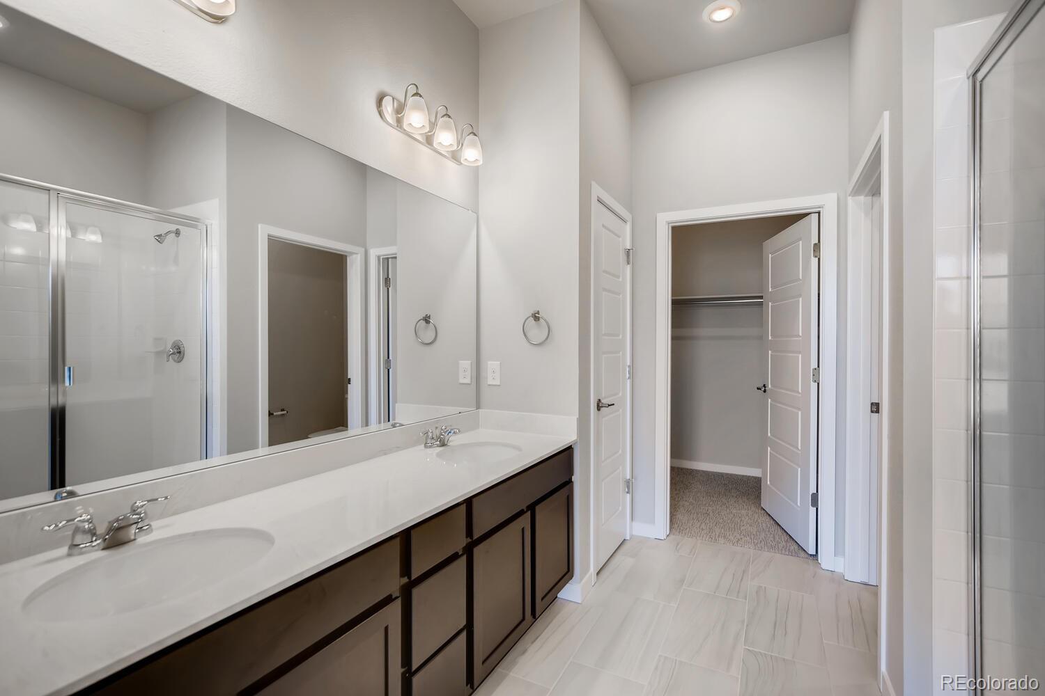 9283 Twenty Mile Road, Unit 406 Parker, CO 80134 - Photo 7 of 13 a bathroom with a double vanity sink mirror and double