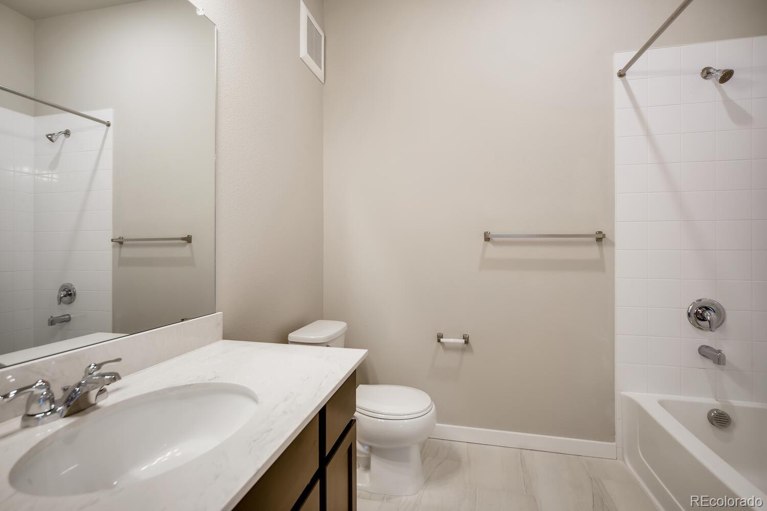 9283 Twenty Mile Road, Unit 406 Parker, CO 80134 - Photo 9 of 13 a bathroom with a sink a toilet and shower
