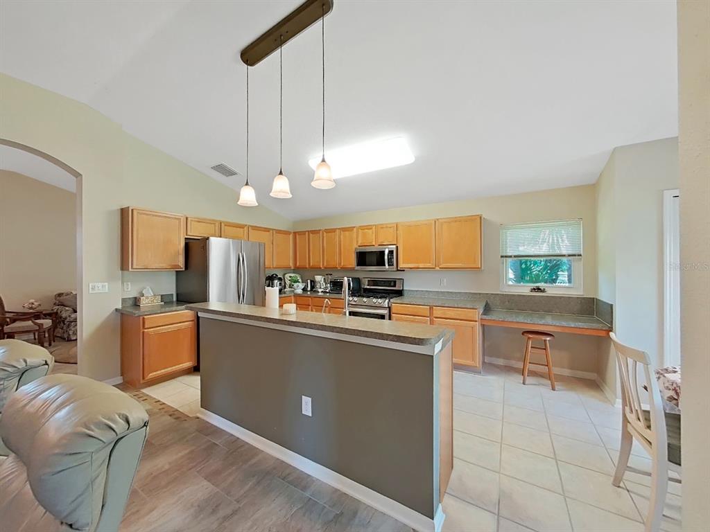 30612 Nickerson Loop Wesley Chapel, FL 33543 - Photo 16 of 47 a kitchen with stainless steel appliances granite countertop a sink and a refrigerator