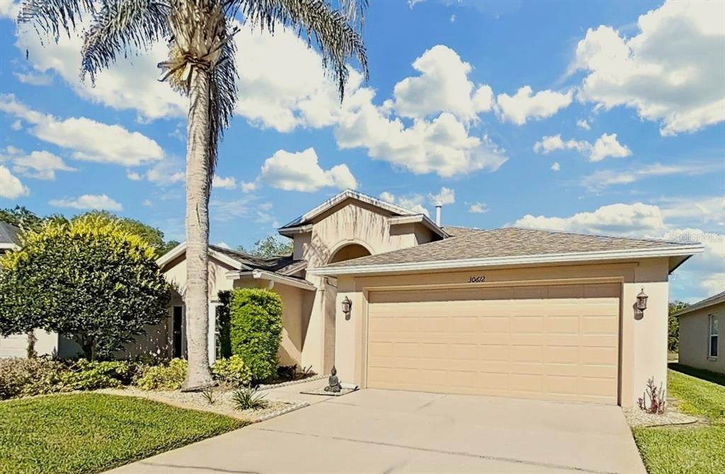 30612 Nickerson Loop Wesley Chapel, FL 33543 - Photo 2 of 47 a front view of a house with a yard and garage