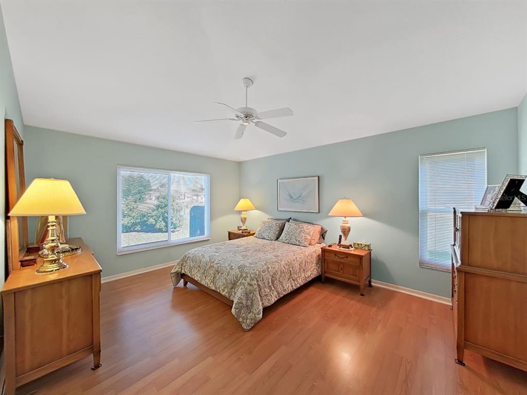 30612 Nickerson Loop Wesley Chapel, FL 33543 - Photo 23 of 47 a bedroom with a bed and wooden floor