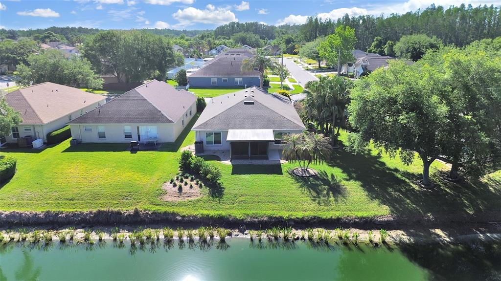 30612 Nickerson Loop Wesley Chapel, FL 33543 - Photo 4 of 47 a aerial view of a house with a garden and lake view