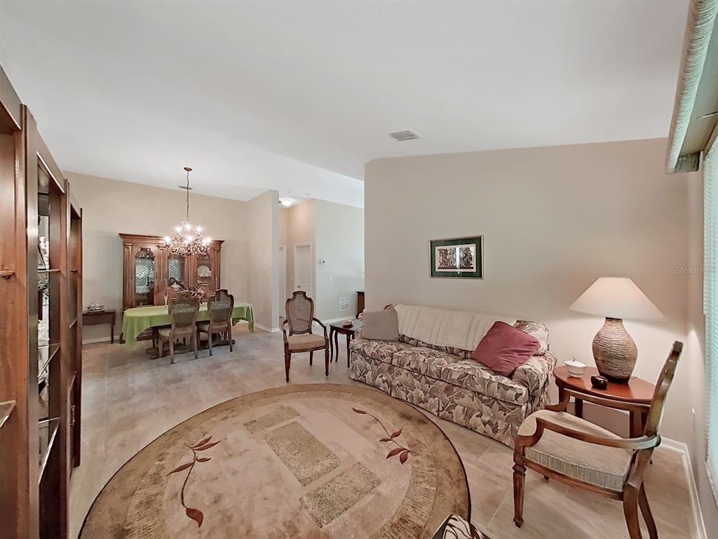30612 Nickerson Loop Wesley Chapel, FL 33543 - Photo 10 of 47 a living room with furniture and a chandelier