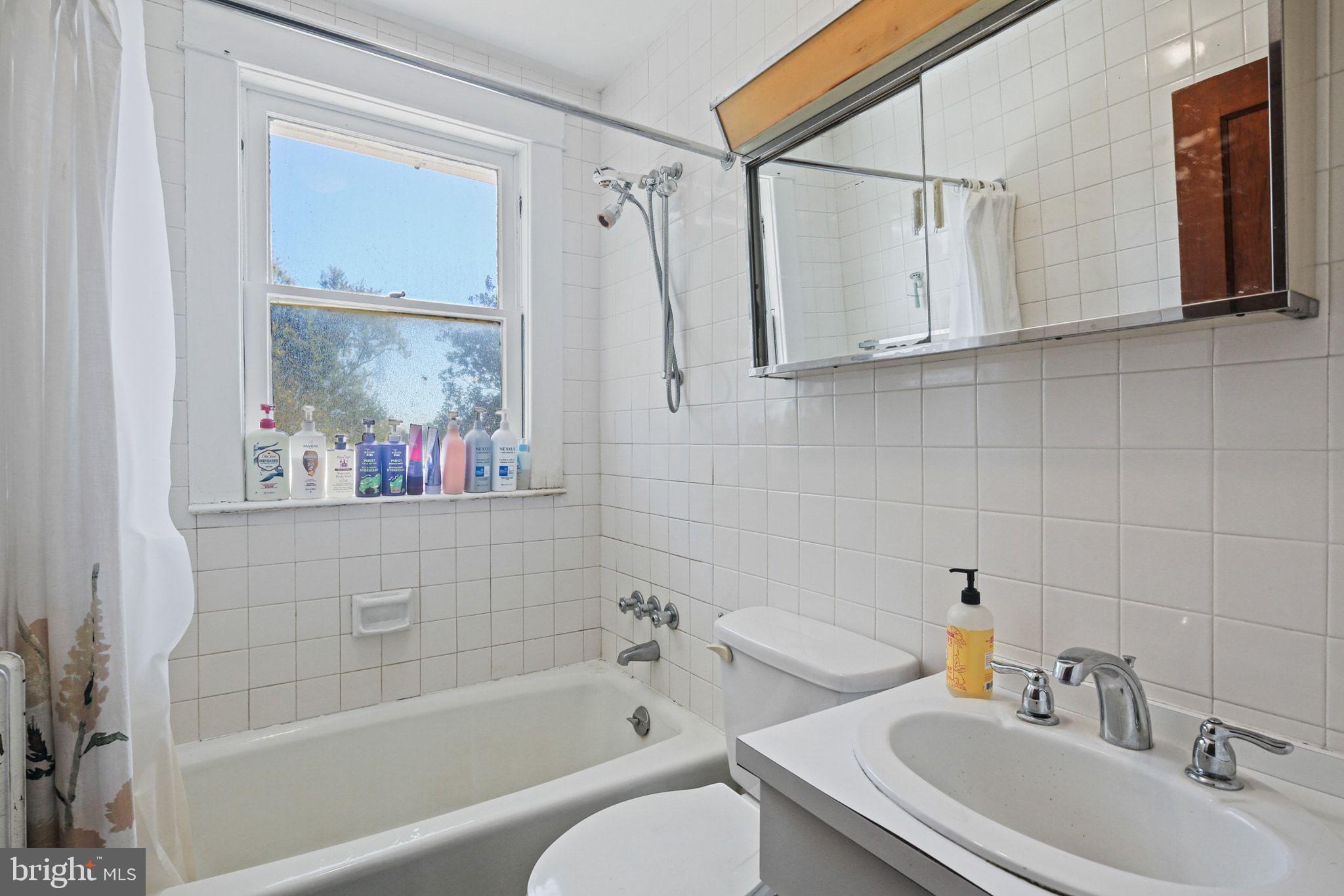 5713 Old Court Road Windsor Mill, MD 21244 - Photo 23 of 31 a bathroom with a sink a mirror a bathtub and shower