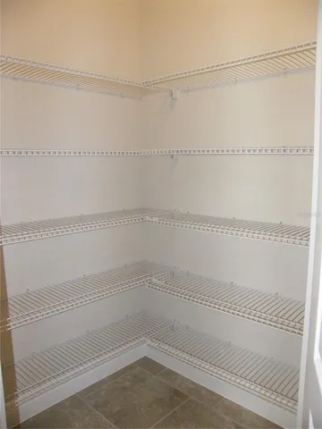 a bedroom with a bed a mirror on dresser and a large window