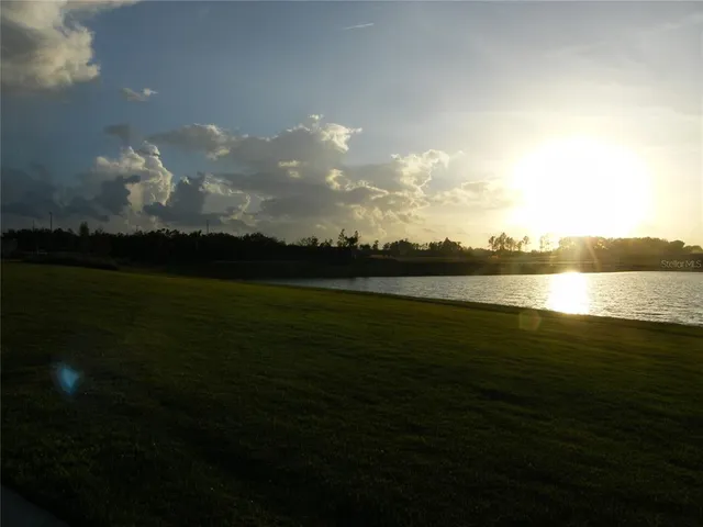 a view of a brick house with a large trees