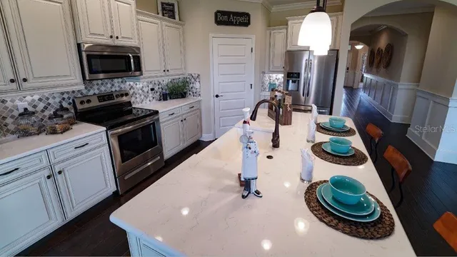 a kitchen with stainless steel appliances granite countertop a refrigerator and a stove top oven