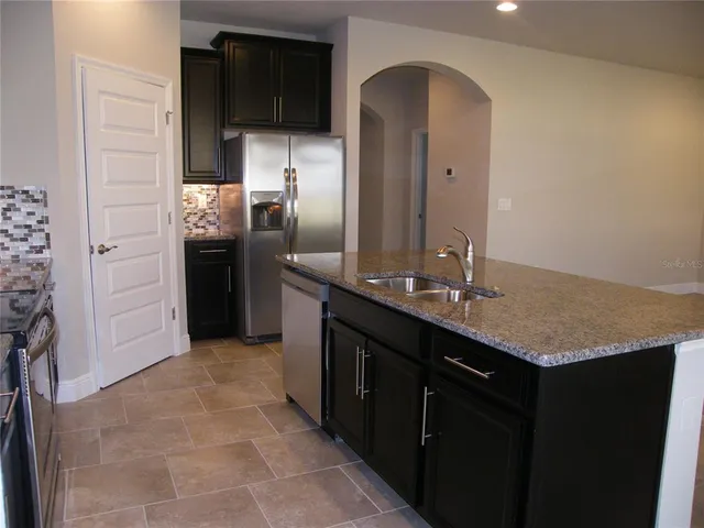 a kitchen with stainless steel appliances granite countertop a sink and a stove