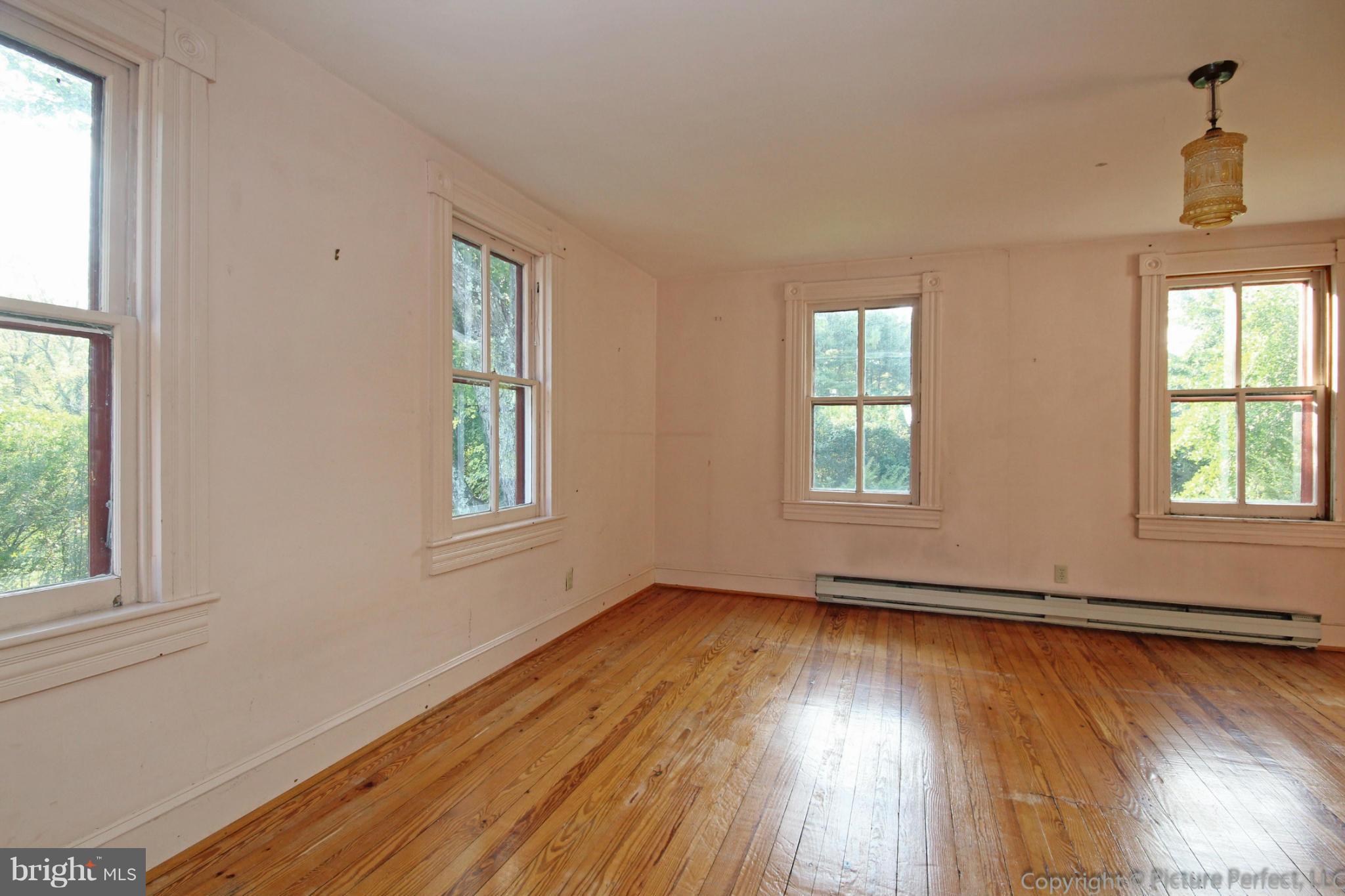 1801 Long Corner Road Mount Airy, MD 21771 - Photo 22 of 30 a view of an empty room with wooden floor and a window