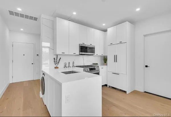 a kitchen with stainless steel appliances a stove top oven a sink and a refrigerator