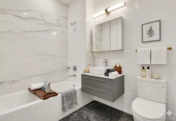 a bathroom with a bathtub sink vanity and toilet