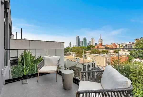 a balcony with chairs and city view