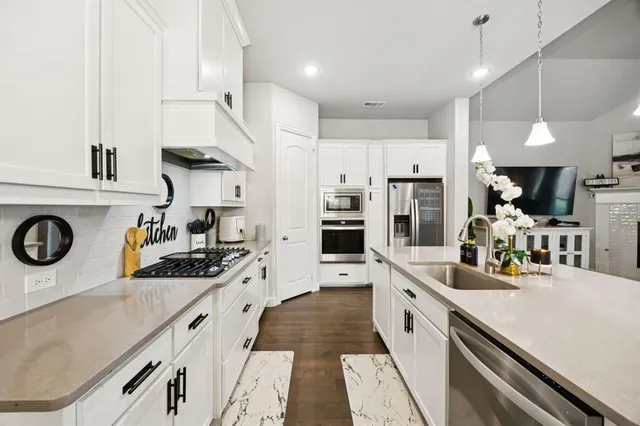 a kitchen with stainless steel appliances granite countertop a sink and cabinets