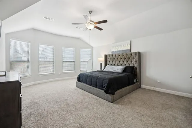a bedroom with a large bed and a chandelier
