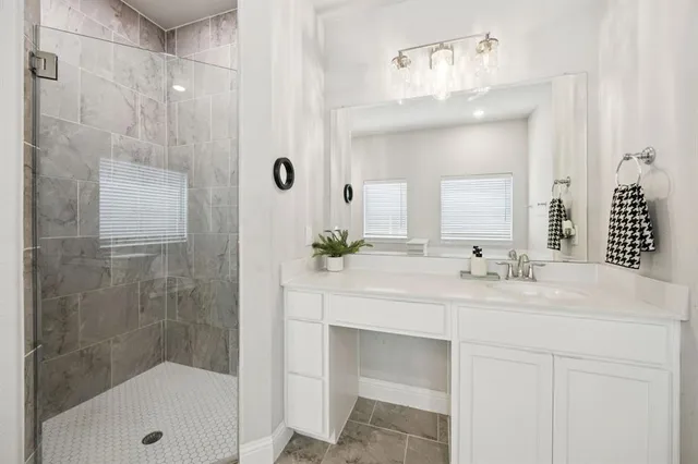 a bathroom with a sink vanity granite tub shower and a mirror