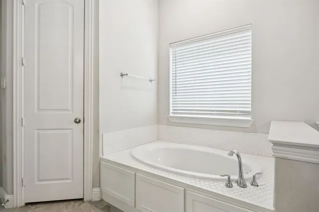 a white bath tub sitting next to a white sink