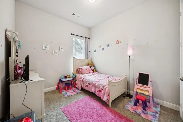 a bedroom with a bed a flat screen tv and dresser