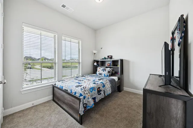 a bed sitting in a bedroom next to a window