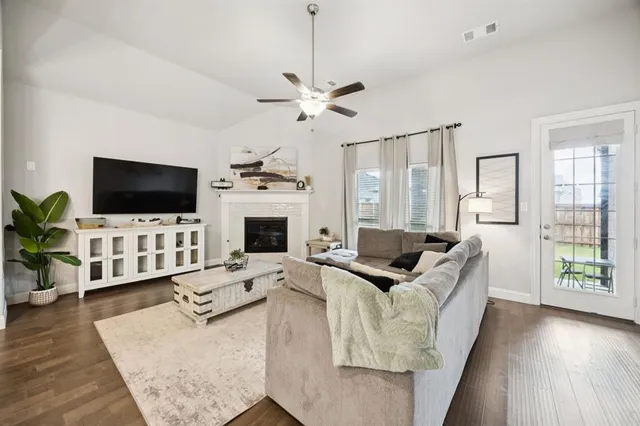 a living room with furniture a flat screen tv and a fireplace