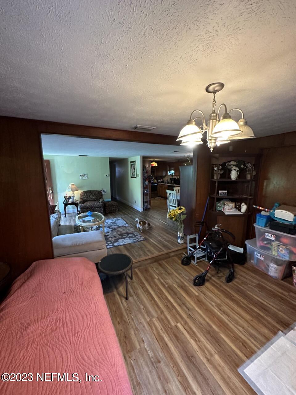 4479 Vinton Road Jacksonville, FL 32207 - Photo 17 of 45 a bed room with a bed mirror and a chandelier