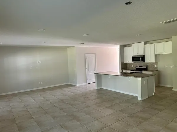 a kitchen with granite countertop a refrigerator sink and cabinets