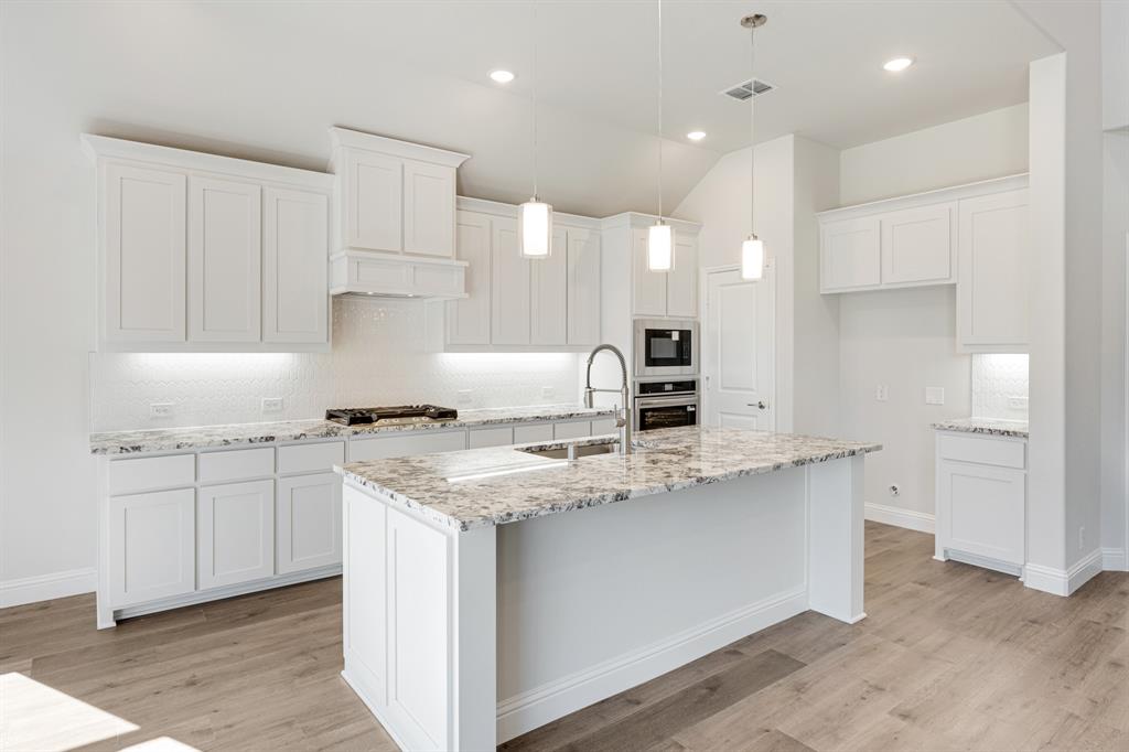 7316 Iris Road Aubrey, TX 76227 - Photo 11 of 40 a kitchen with stainless steel appliances granite countertop a sink a stove and a refrigerator
