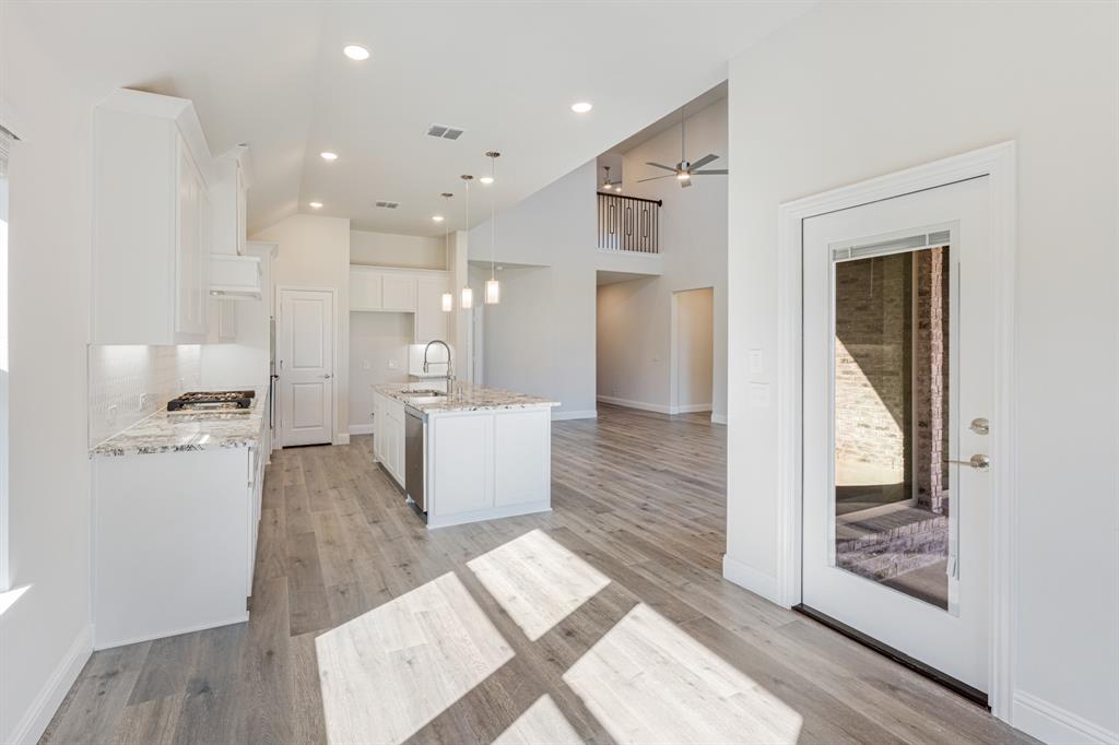 7316 Iris Road Aubrey, TX 76227 - Photo 13 of 40 a large living room with stainless steel appliances furniture a rug and a kitchen view