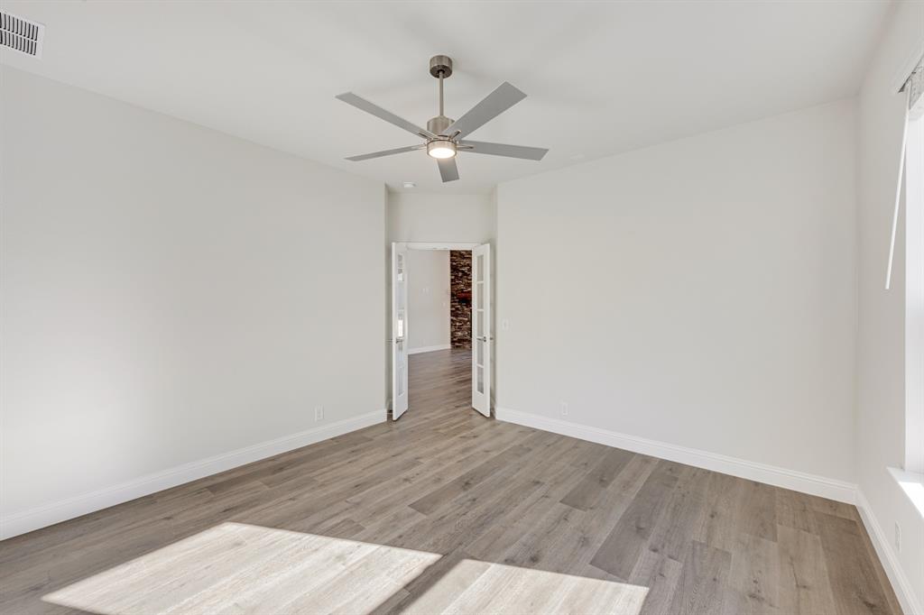 7316 Iris Road Aubrey, TX 76227 - Photo 16 of 40 an empty room with wooden floor ceiling fan and window