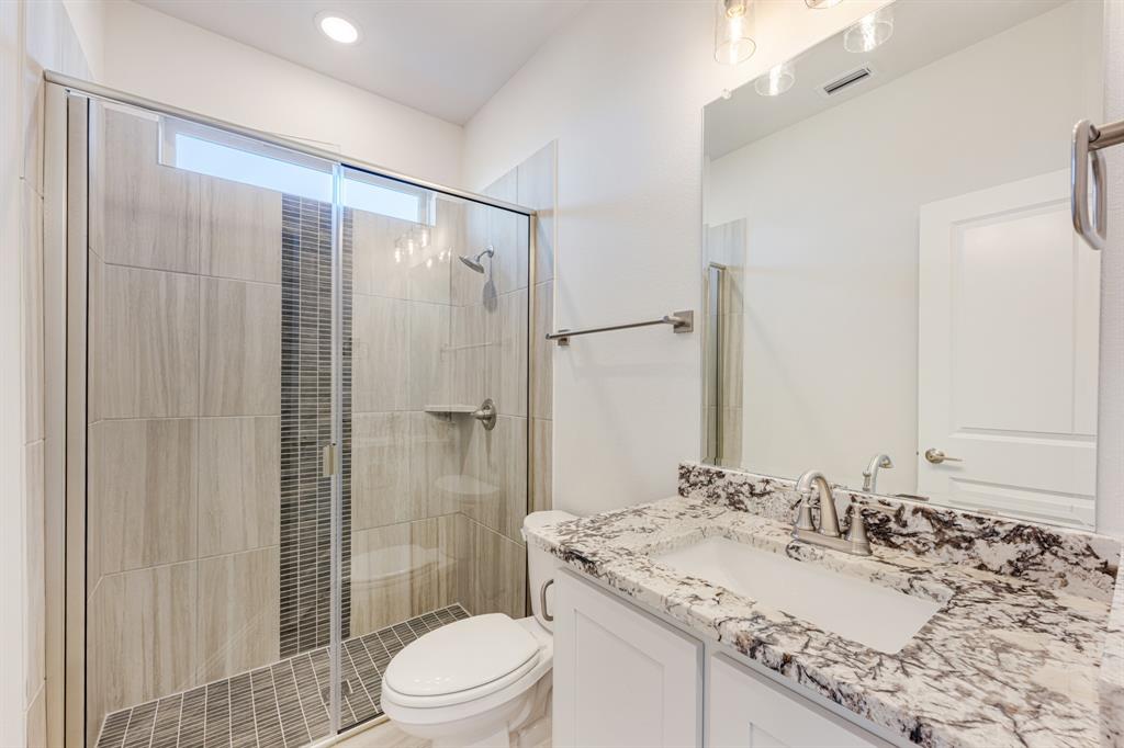 7316 Iris Road Aubrey, TX 76227 - Photo 22 of 40 a bathroom with a granite countertop sink toilet and shower