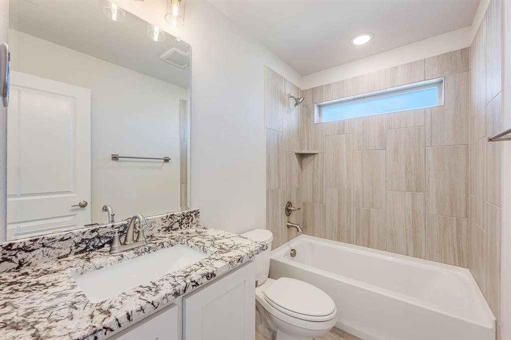 7316 Iris Road Aubrey, TX 76227 - Photo 31 of 40 a bathroom with a granite countertop sink toilet and shower