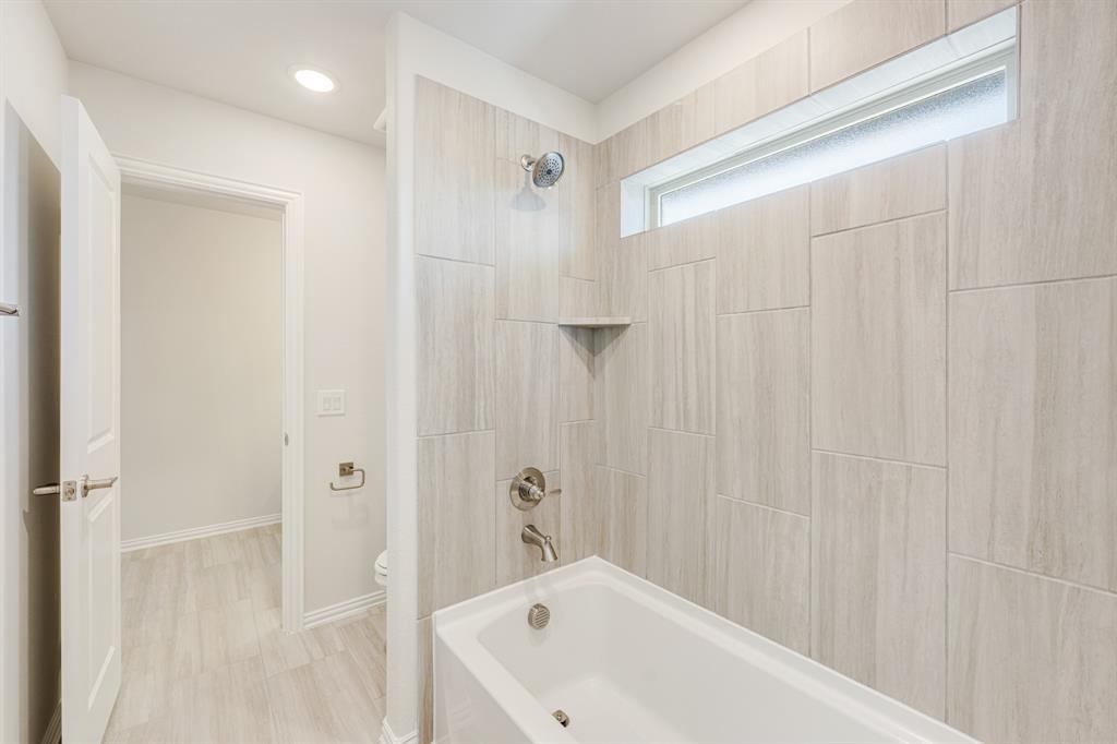 7316 Iris Road Aubrey, TX 76227 - Photo 34 of 40 a bathroom with a white bath tub