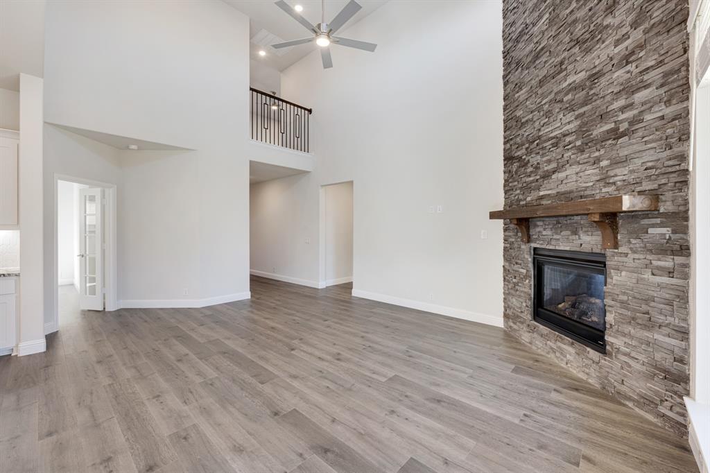 7316 Iris Road Aubrey, TX 76227 - Photo 6 of 40 a view of an empty room with wooden floor fireplace and a window