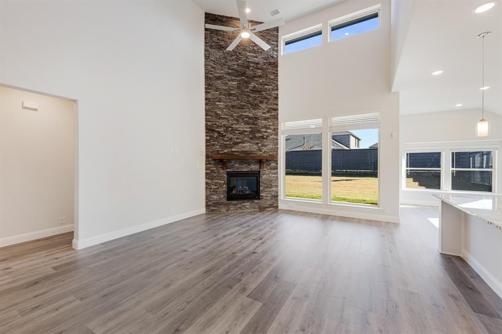 7316 Iris Road Aubrey, TX 76227 - Photo 7 of 40 a view of empty room with wooden floor and fireplace