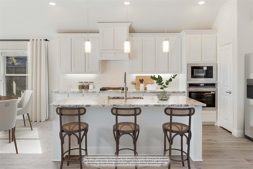 7316 Iris Road Aubrey, TX 76227 - Photo 10 of 40 a kitchen with a table chairs refrigerator and microwave