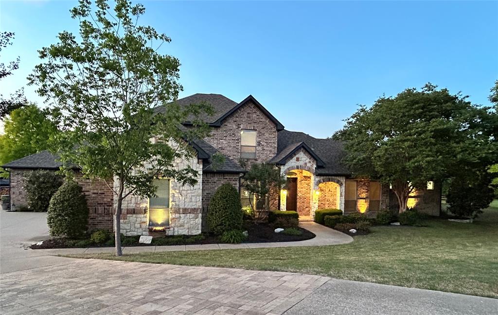 1520 Snider Court Lucas, TX 75002 - Photo 2 of 40 This stunning property features a beautiful brick and stone facade and an exceptionally well-maintained lawn with mature trees and landscape.