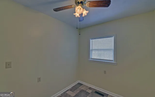a view of a room with a chandelier fan