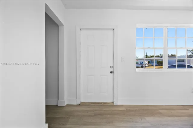 a view of kitchen with wooden floor and cabinets