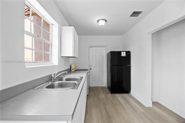 a kitchen with a sink and refrigerator