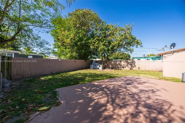 a view of a yard with an tree and wooden fence