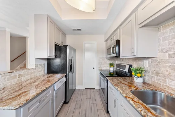 a kitchen with stainless steel appliances granite countertop a sink stove and refrigerator