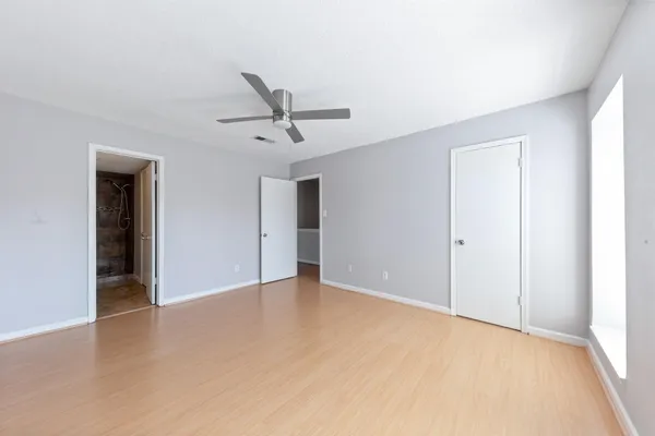 a view of an empty room with closet and a window