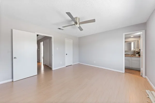 an empty room with closet and a ceiling fan