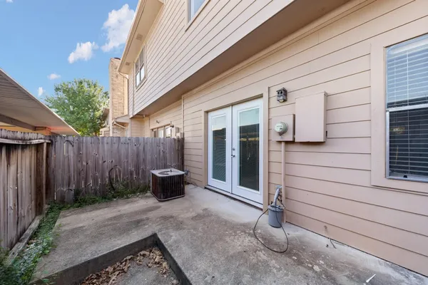 a backyard of a house with barbeque oven and potted plants