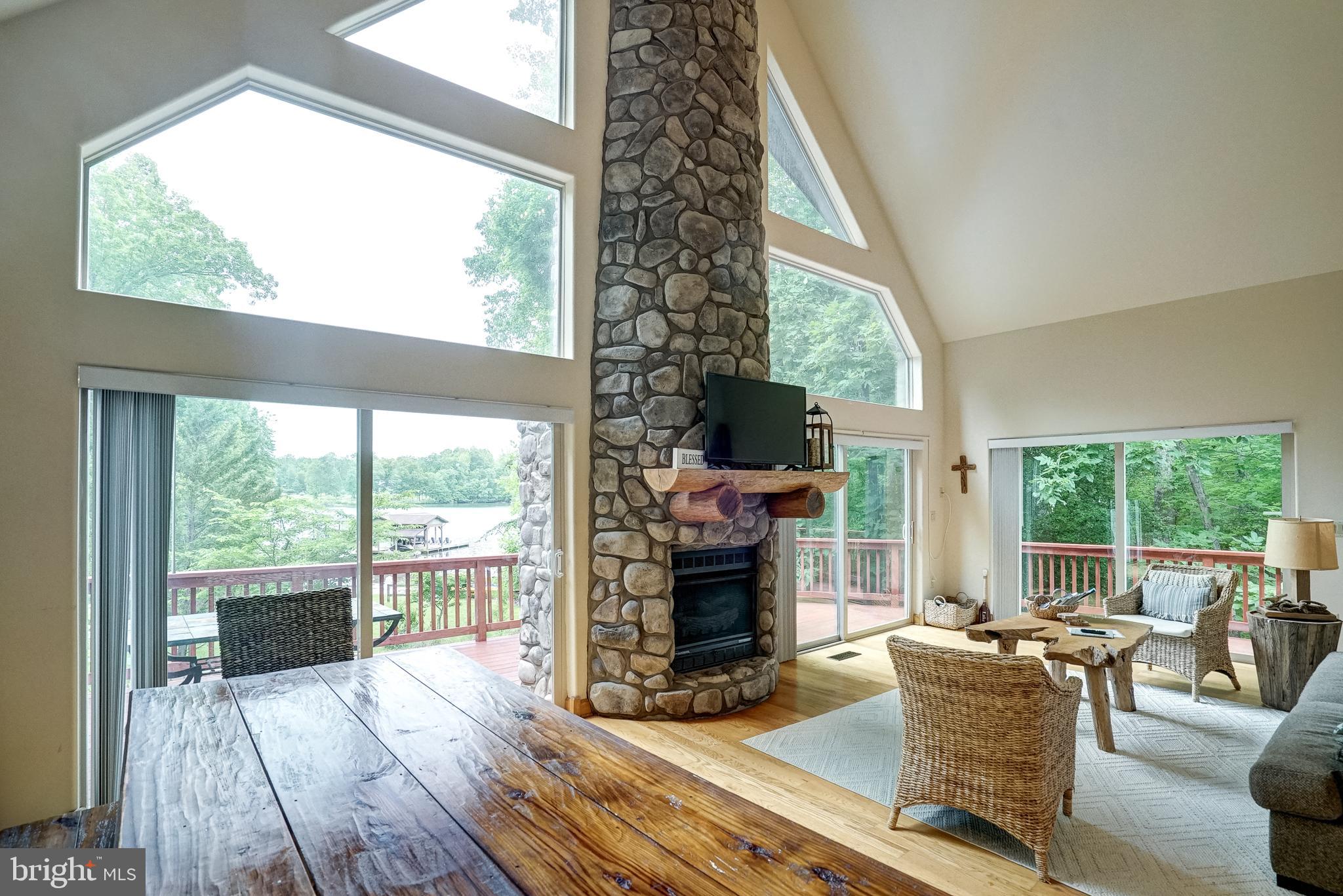 155 Irish Way Bumpass, VA 23024 - Photo 11 of 60 a living room with fireplace furniture a flat screen tv and a floor to ceiling window