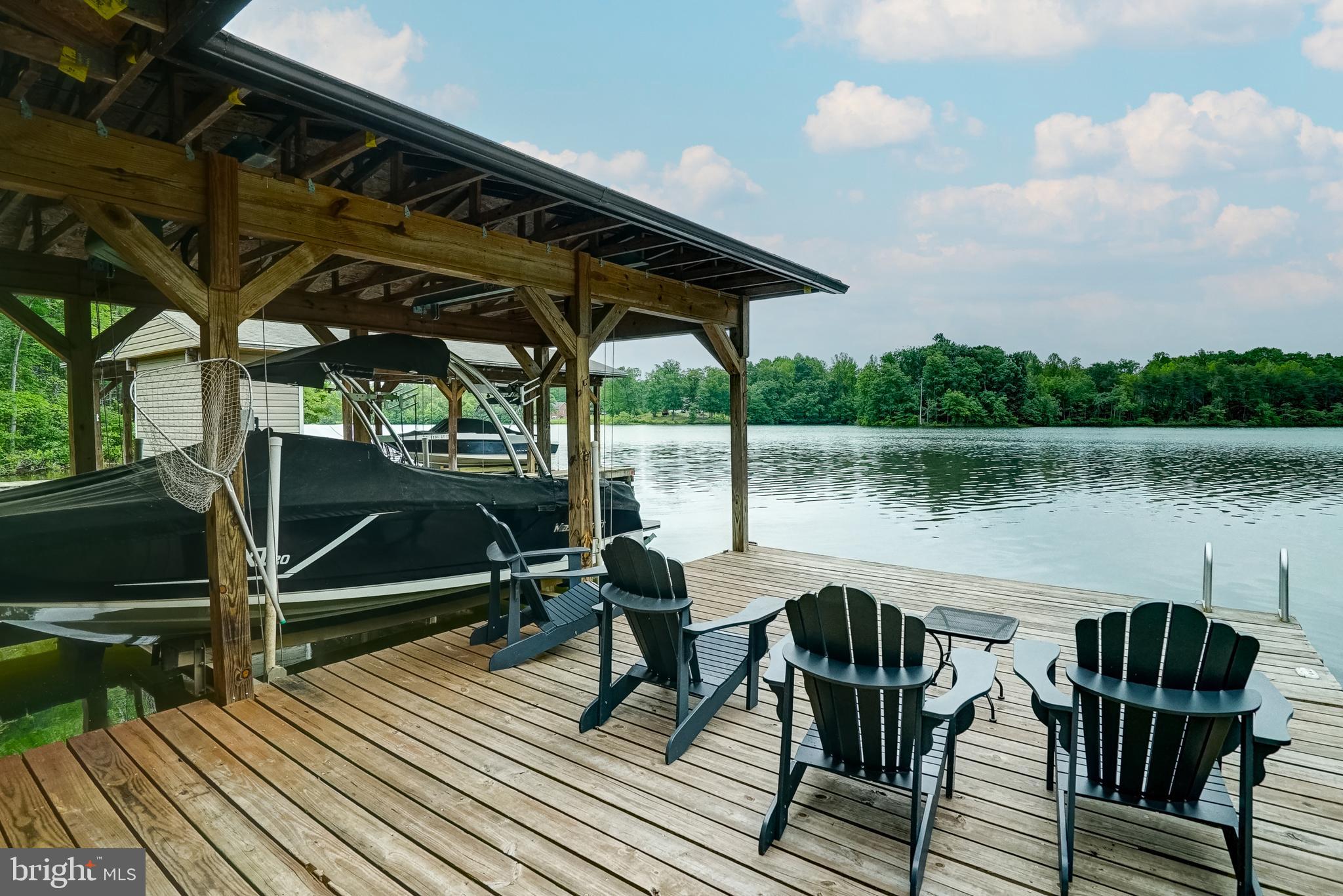 155 Irish Way Bumpass, VA 23024 - Photo 3 of 60 a view of a lake from a roof deck with table and chairs a barbeque with wooden floor and fence