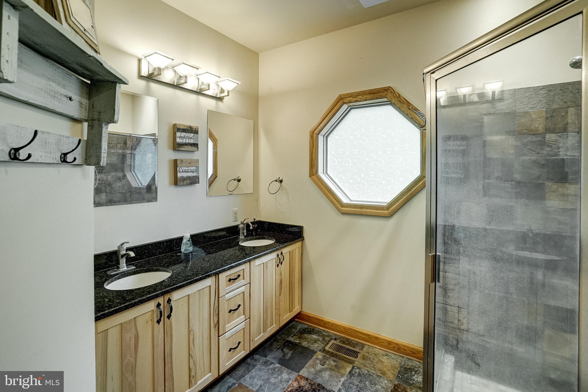 155 Irish Way Bumpass, VA 23024 - Photo 34 of 60 a bathroom with a sink a mirror and a shower